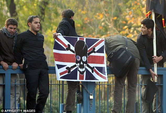 Sinh viên Tehran đốt cờ của Anh. Một sinh viên khác đang cố tháo quốc huy của Hoàng gia Anh bên ngoài Đại sứ quán Anh ở Tehran